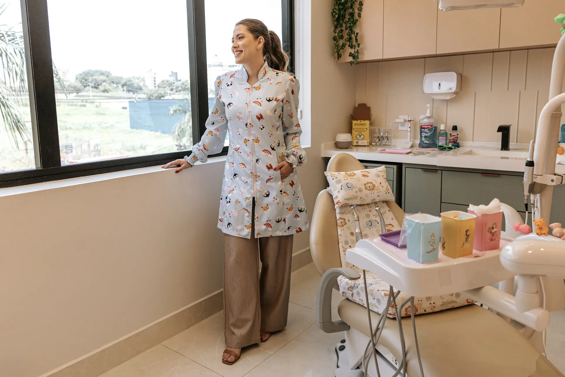 Consultório odontopediátrico com cadeira infantil e decoração de animais